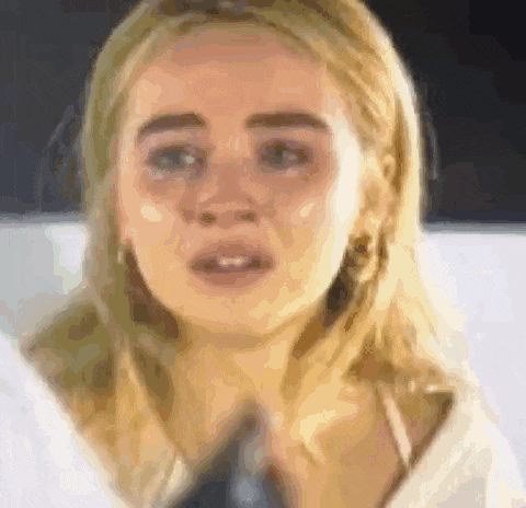 a close up of a woman 's face with a tear running down her cheek .
