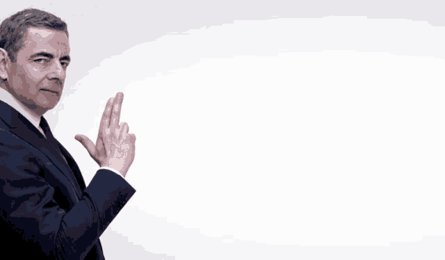 a man in a suit and tie is pointing his finger at something