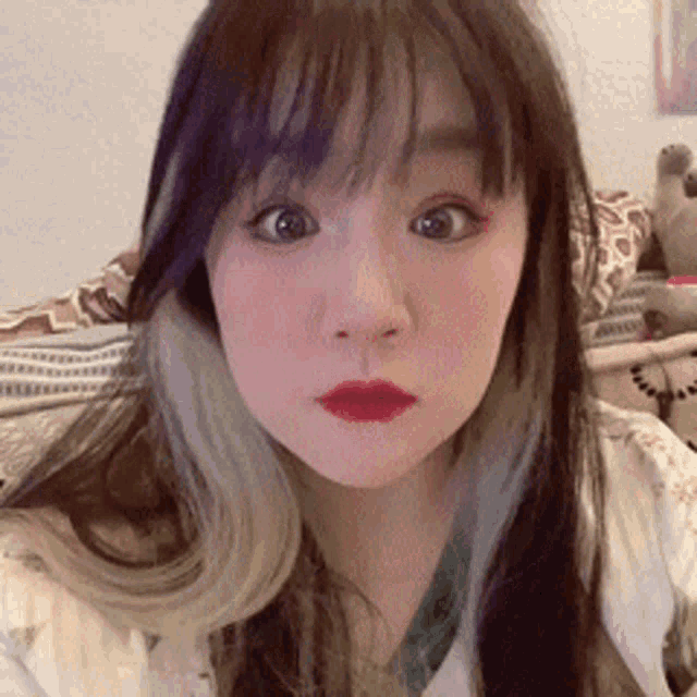 a close up of a woman 's face with long hair and red lips