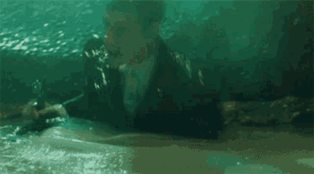 a man in a suit is swimming underwater