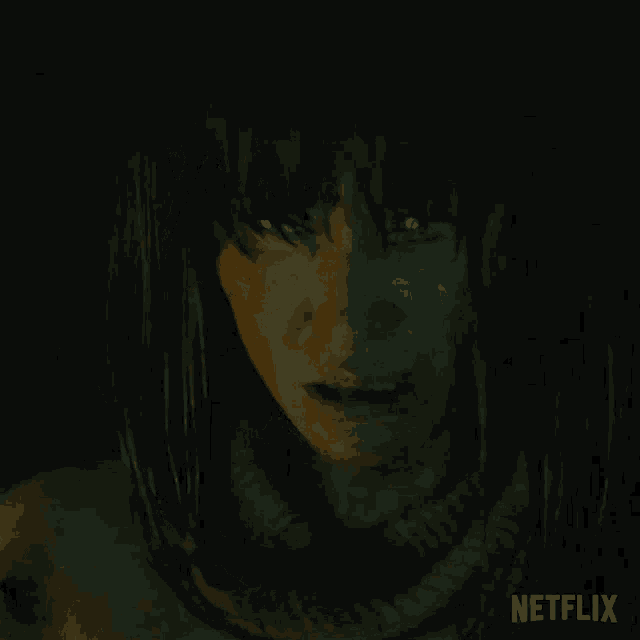 a close up of a person 's face in a dark room with a netflix logo in the corner .