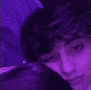 a close up of a person 's face with purple lights behind them .