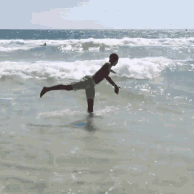 a man in green shorts is doing a trick on a surfboard in the ocean