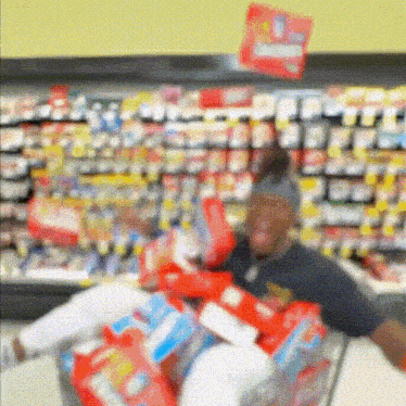 a blurred image of a person in a grocery store with a sign above them that says ' chicken '
