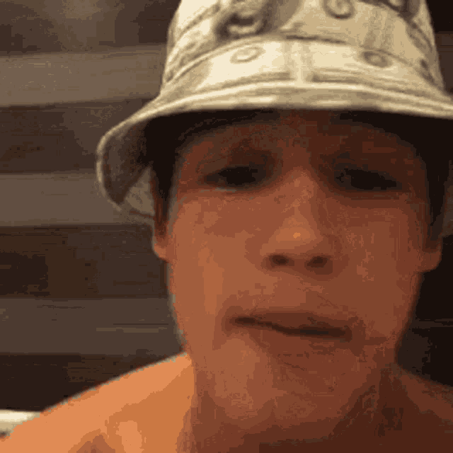 a young man wearing a hat with money on it