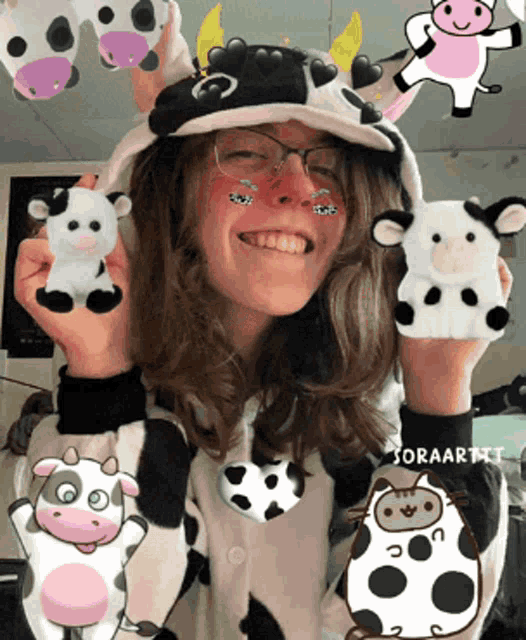 a girl in a cow costume is holding stuffed cows in her hands