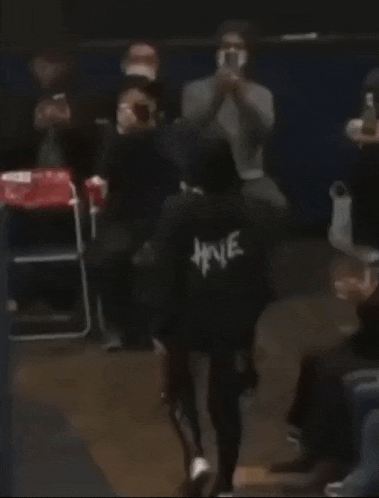 a person wearing a black hoodie with the word hive on the back