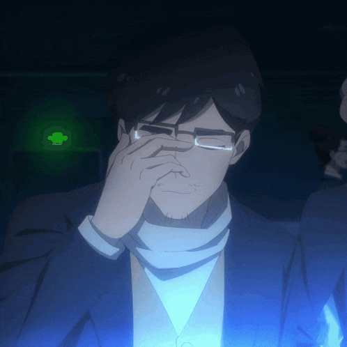 a man wearing glasses is covering his nose in front of a green light
