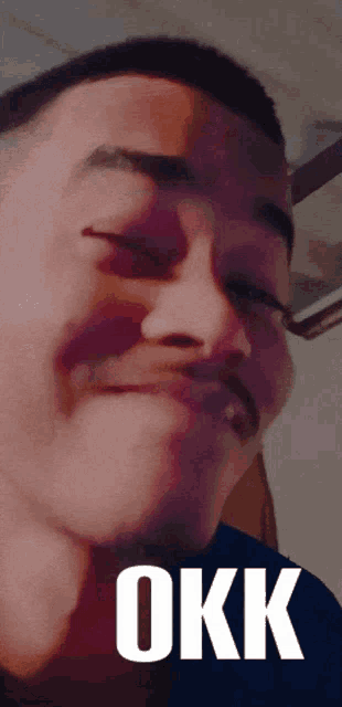 a close up of a man 's face with the word okk on the bottom right