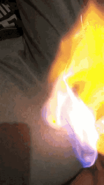 a close up of a person holding a lighter with a flame coming out