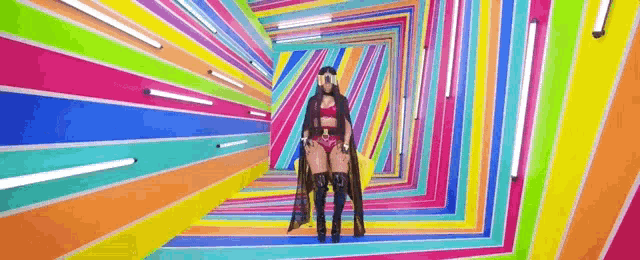 a woman is standing in a colorful tunnel with a lot of lights .
