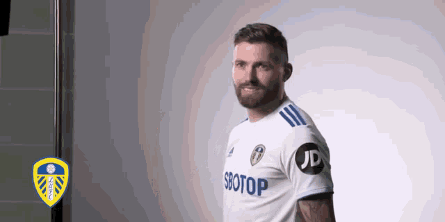 a man with a beard is wearing a white jersey that says jd on it .