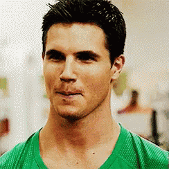a close up of a man wearing a green shirt .