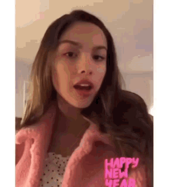 a woman in a pink jacket is making a funny face .