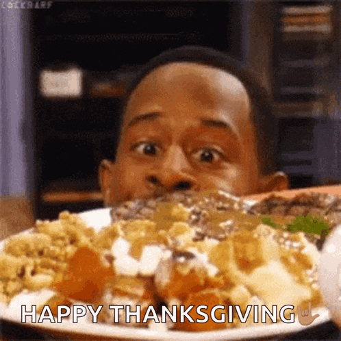 a man is eating a plate of food with the words happy thanksgiving on it .