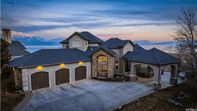 a large house with mountains in the background and the number 164 on the front