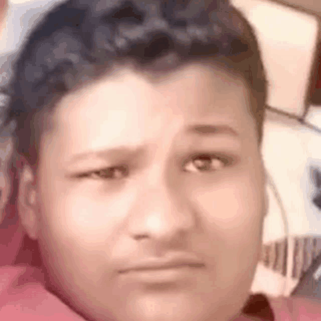 a close up of a boy 's face with a serious look on his face .