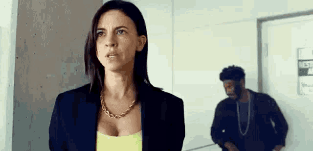 a man and a woman are standing next to each other in a hallway .