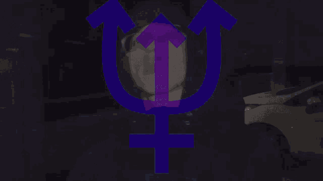 a man is standing in a dark room with a purple light behind him .