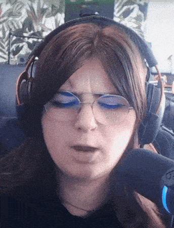 a woman wearing headphones and glasses is looking down