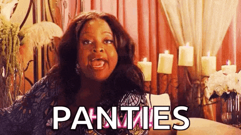 a woman is sitting on a couch with candles in the background and the word panties written on her face .