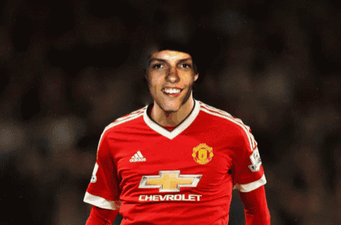 a man in a red chevrolet jersey smiles