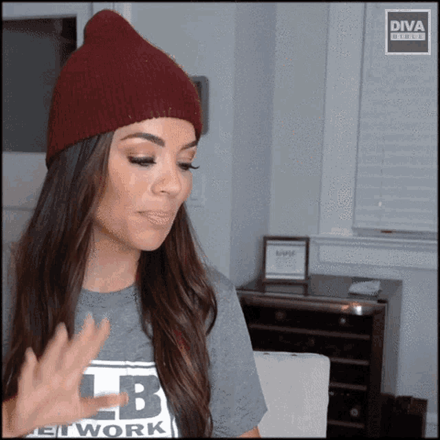 a woman wearing a beanie and a t-shirt with the letters lb on it