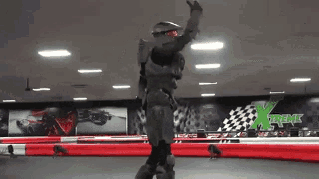 a man in a spartan costume is rollerblading on a track with xtreme on the wall behind him