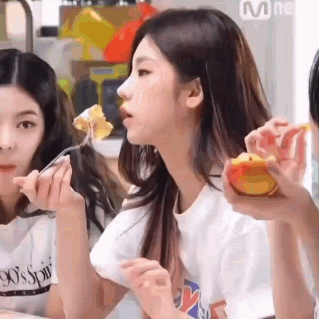 a girl is eating a piece of food with a fork .