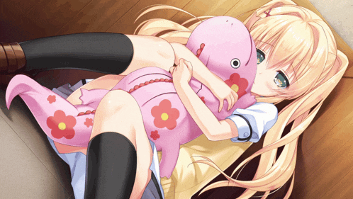 a girl is laying on a bed holding a pink stuffed animal with flowers on it