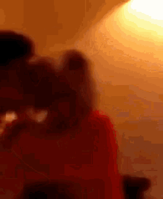 a blurry picture of a man and woman kissing in a bedroom .