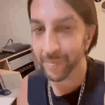 a man with a beard is making a funny face in a room .