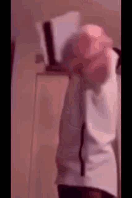 a blurry picture of a person holding a book in their hands .