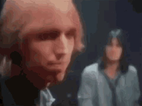 a man and a woman are standing next to each other in a blurry photo .