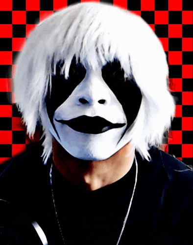 a man wearing a black and white mask with a checkered background