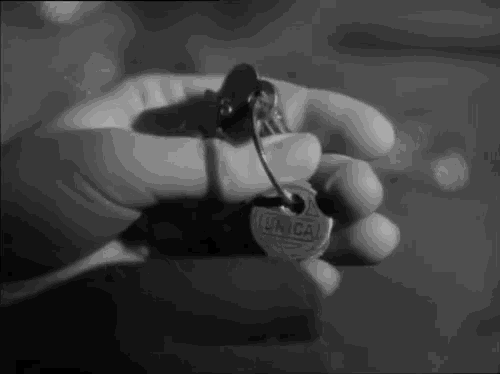 a black and white photo of a person holding a unica key