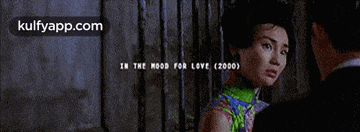 a man and a woman are looking at each other in a movie called in the mood for love