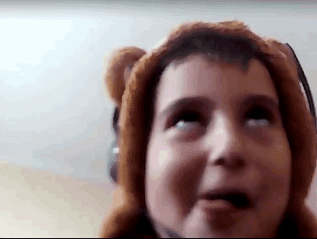 a close up of a person wearing a teddy bear hat and headphones .