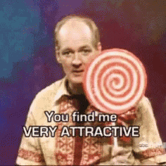 a man is holding a spiral lollipop and says you find me very attractive .