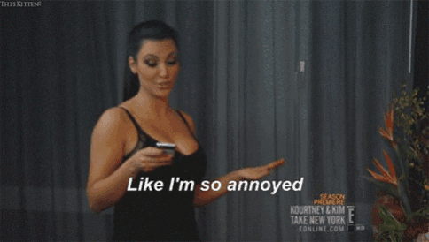 a woman in a black bra is holding a cell phone and saying like i 'm so annoyed
