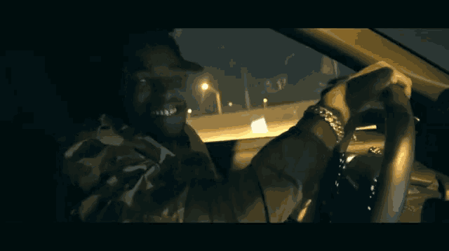 a man in a camo jacket is driving a car