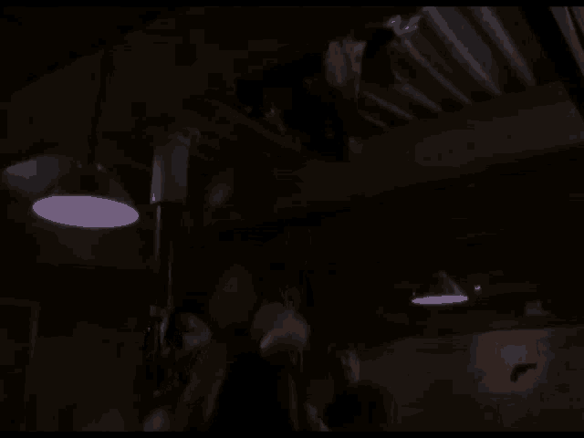 a man is hanging upside down from a pole in a dark room