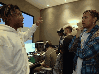 a group of young men are standing in a room with headphones on