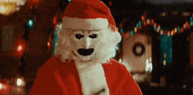 a person dressed as santa claus with a white mask on their face .