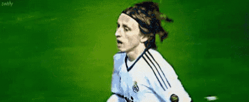 a soccer player with a headband on his head is running on a field .