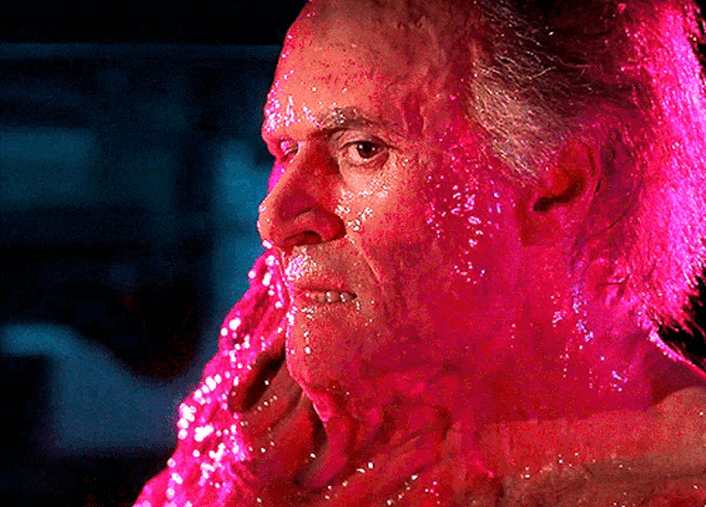 a close up of a man 's face with pink liquid on it