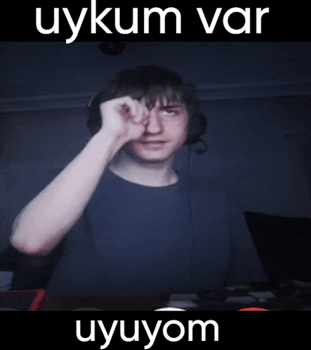 a man wearing headphones is making a funny face with the words uykum var uyuyom behind him