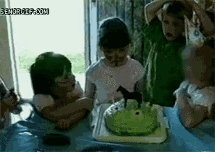 a group of children are celebrating a birthday with a green cake