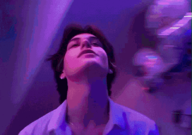 a man in a blue shirt looks up at something