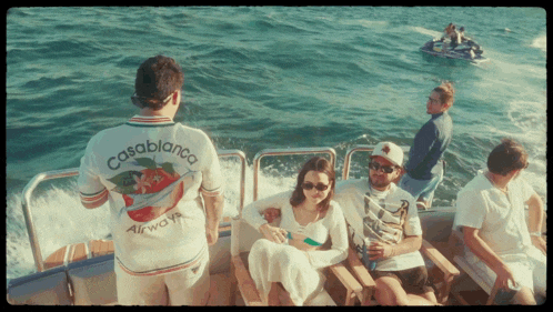 a man wearing a casablanca airways shirt is standing on a boat